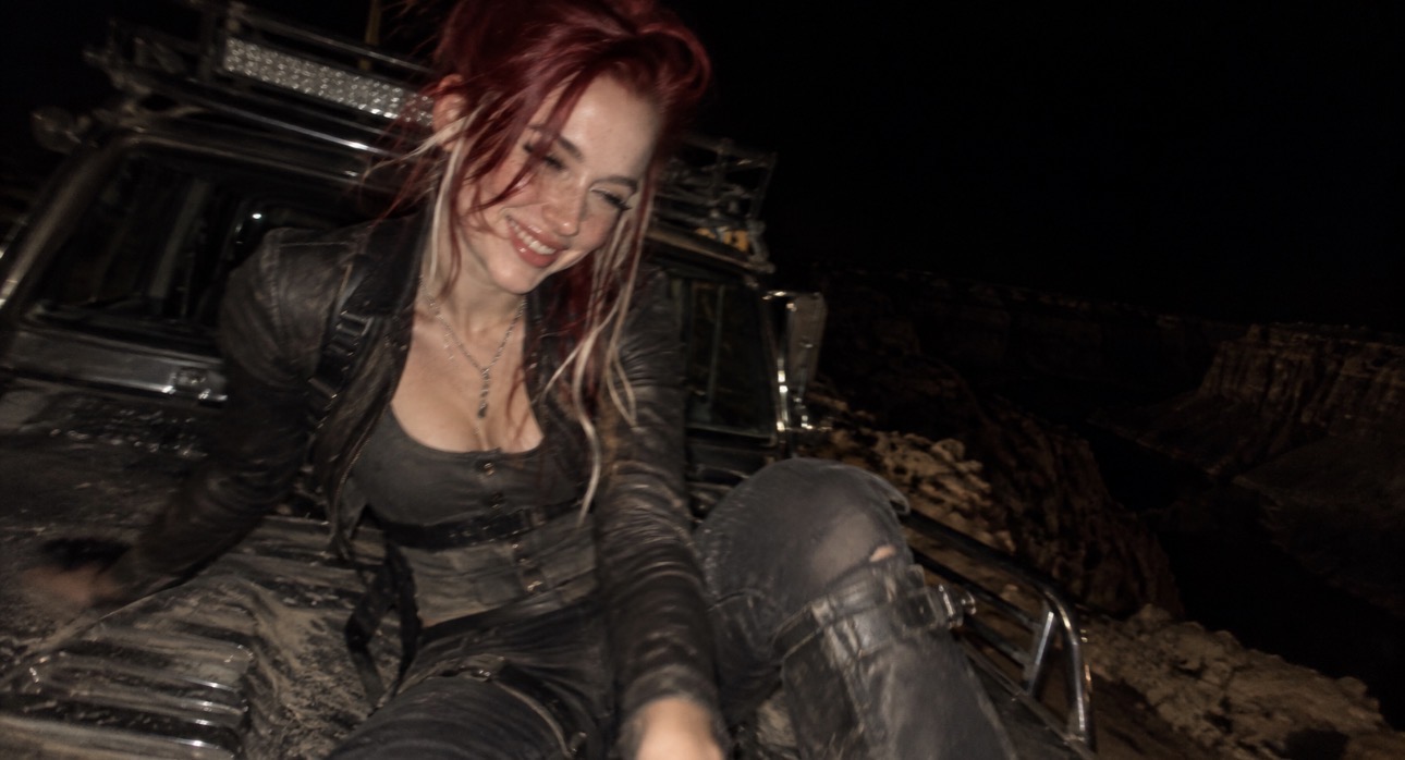 Alice Kwong smiling beside an off-road car at night