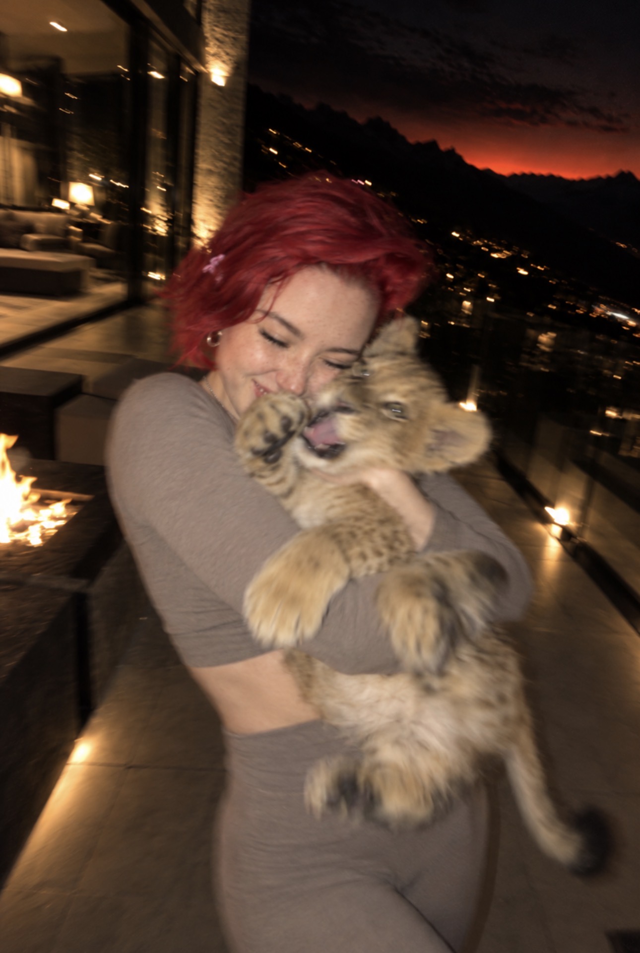 Alice Kwong cuddling a lion cub in a playful candid portrait