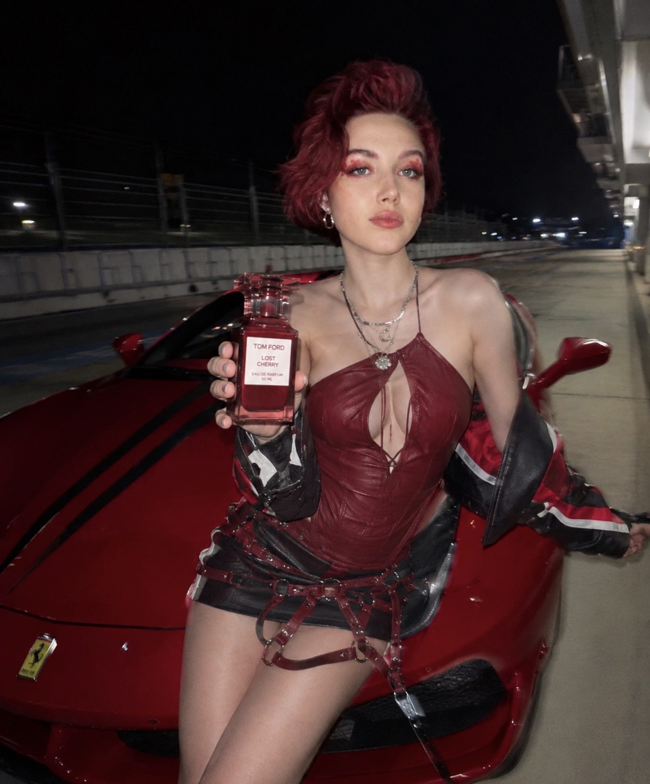 Alice Kwong holding Tom Ford perfume near a red car