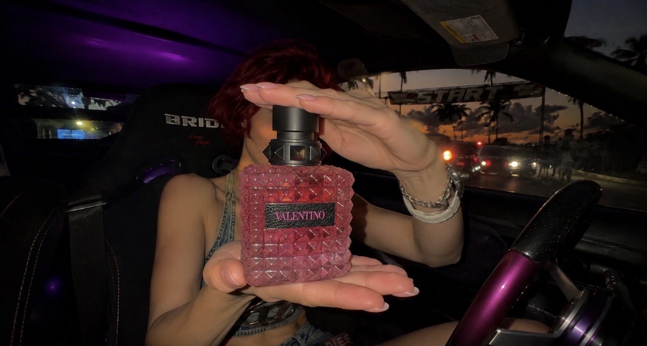 Red Valentino perfume product shot inside a car